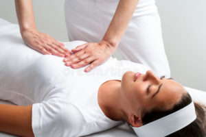 therapist-pressing-hands-womans-chest-reiki-session-close-up-chiropractor-56593814